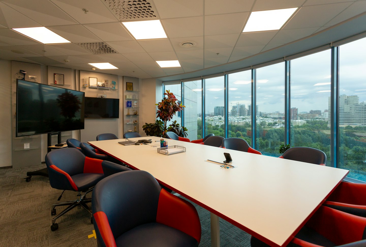 Sala de conferencias moderna y vacía con vistas al perfil de la ciudad a través de las ventanas.