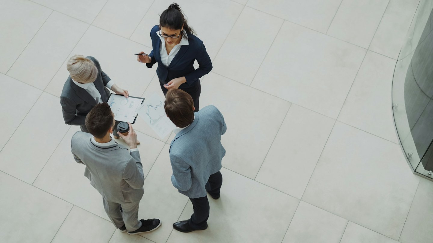 Profesionales de negocios colaborando sobre gráficos en una oficina moderna.